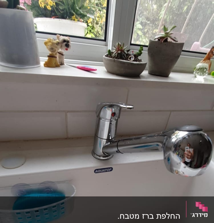 ברז מטבח כסוף עם כיור לבן ומסננת